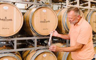 Winemaker drawing wine from a barrel